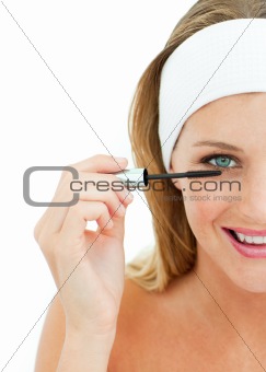Young woman putting mascara