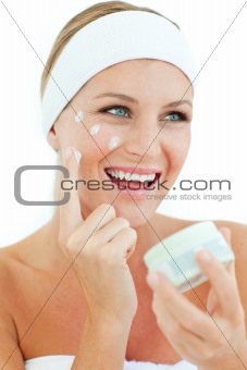 Jolly woman putting cosmetic cream