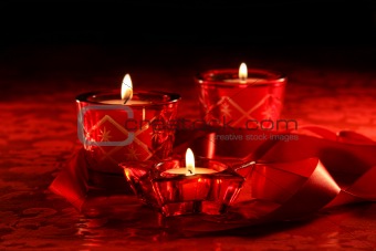 Votive candles on dark red background