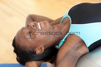 Happy ethnic woman working out with a pilates ball 