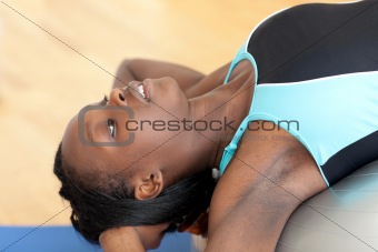 Afro-american woman doing sit-ups with a gym ball