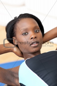 Concentrated woman in gym outfit doing sit-ups
