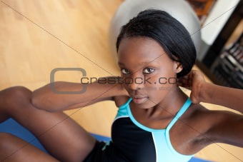 Beautiful woman in gym outfit doing sit-ups