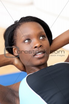 Ethniic woman in gym outfit doing sit-ups 