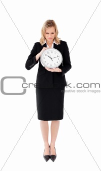 Glum businesswoman holding a clock
