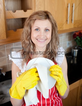 Smiling young woman cleaning in a kitchen at home