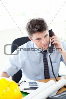 Serious male architect talking on phone  