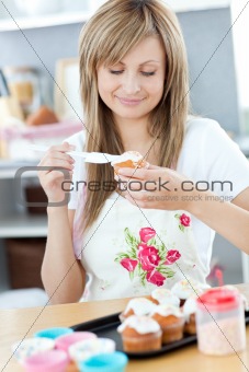 Delighted woman preparing cakes in the kitchen 