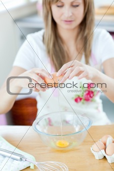 Smiling woman preparing eggs in the kitchen 