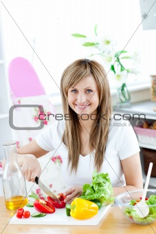 Young woman preparing a salad in the kitchen 