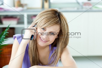 Delighted woman talking on the phone in the kitchen 