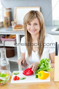 Teen woman preparing a salad in the kitchen 