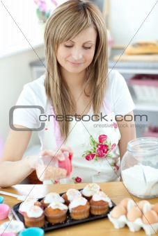 Portrait of a confident woman preparing a cake in the kitchen
