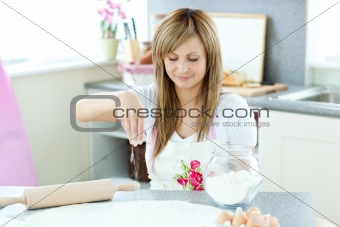 Portrait of a cute woman preparing a cake in the kitchen 