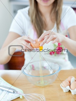 Close-up of a young woman preparing a cake in the kitchen 