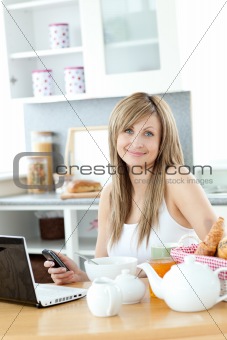 Cute woman having breakfast in the kitchen 