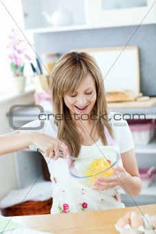 Delighted woman preparing eggs in the kitchen 