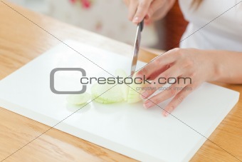 Delighted woman preparing oinion in the kitchen 