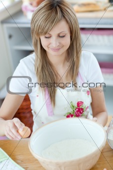 Portrait of a happy woman preparing a cake in the kitchen
