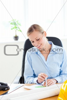 Attractive female architect studying a project  