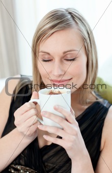 Relaxed woman drinking a coffee sitting on a sofa 