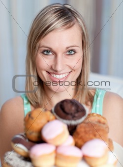 Bright woman holding a plate of cakes 