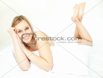 Radiant blond woman lying down on bed