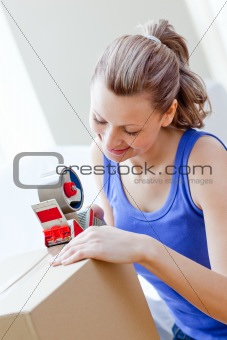 Beautiful woman packing boxes in the living-room