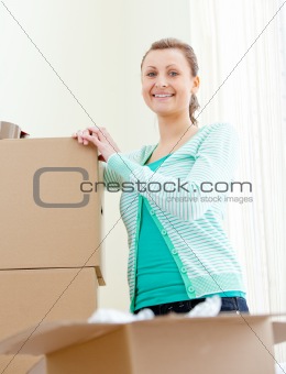 Attractive woman writing on boxes using a pen 