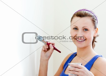 Smiling woman is decorating a room 