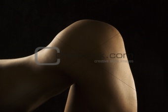 Nude woman bending over.