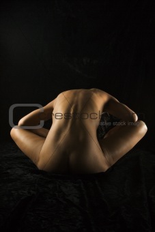 Nude woman sitting.