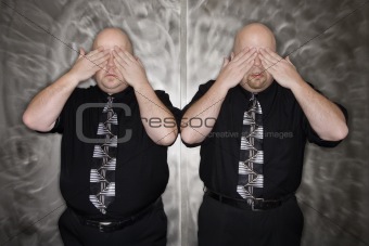 Twin men covering eyes.
