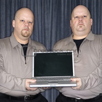 Identical twin men with laptop.