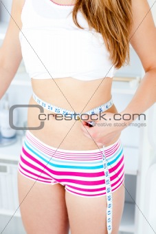 Caucasian woman mesuring her body