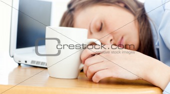 Slumbery woman sleeping on table in office