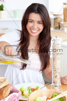 Jolly woman prepare a salad smiling at the camera