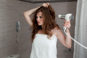 attractive woman using fen in bathroom