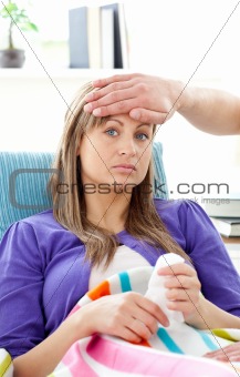 Depressed woman lying on a sofa man feel her temperature