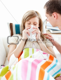 Ill woman with tissue lying on  a sofa