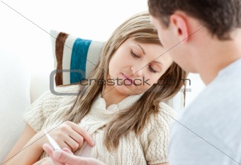Sad woman with boyfriend holding a pill