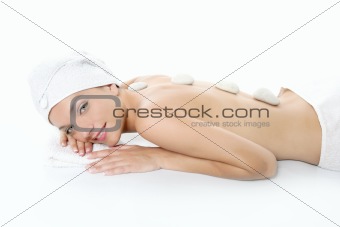 Beautiful woman relaxed on spa with stone treatment
