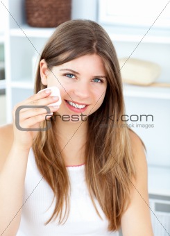 Beautiful woman putting make-up on her face