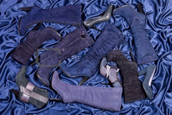 Female blue boots and shoes placed on blue draped satin