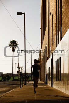 Silhouette of woman running in the morning