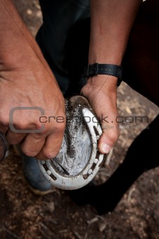 Close up of a man cleaning a horseshoe