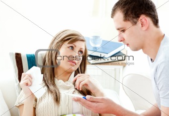 Loving boyfriend holding a thermometer of his ill girlfriend 