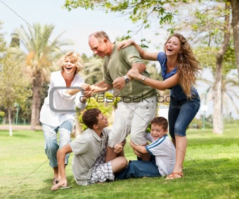 Family holding back grandfather and having fun