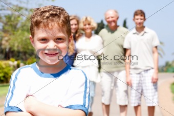 Young cute boy in focus with family in the background