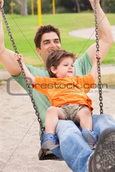 Father enjoying swing ride with his son